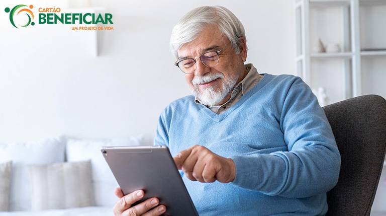 Homem idoso mexendo em um tablet. Por mais que não se saiba como começa o Alzheimer, manter a atividade cerebral é uma forma de preveni-lo.